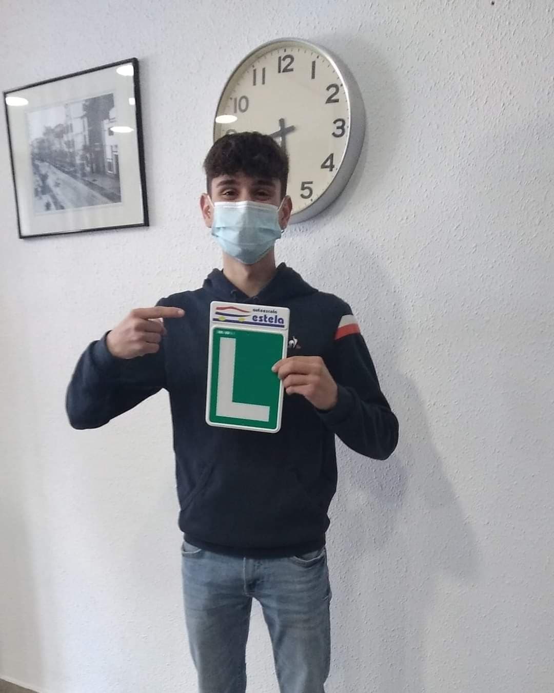 Alumno de Autoescuela Estela mostrando la placa L de Autoescuela Estela tras superar su examen